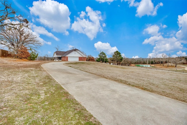 view of yard with a garage and a rural view