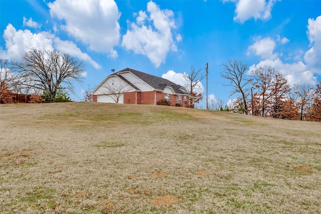 view of side of property featuring a lawn and an attached garage