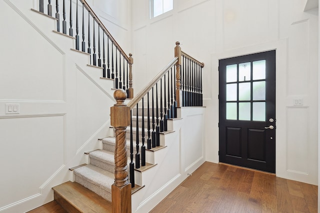 foyer entrance featuring plenty of natural light, a decorative wall, and wood finished floors