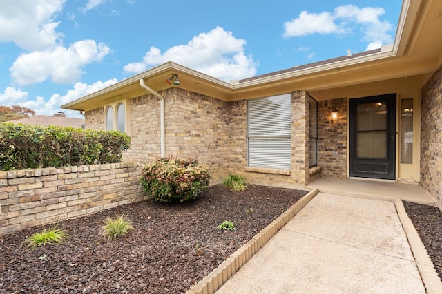 doorway to property with brick siding