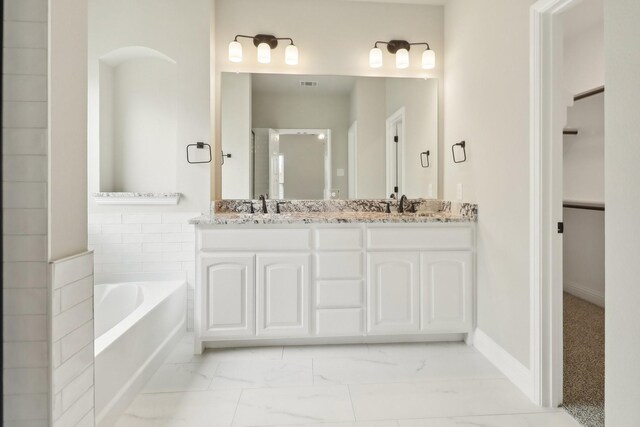 212 Navajo Trl, Alvarado, TX 76009 - full bath featuring a walk in closet, a sink, marble finish floor, visible vents, and a bath