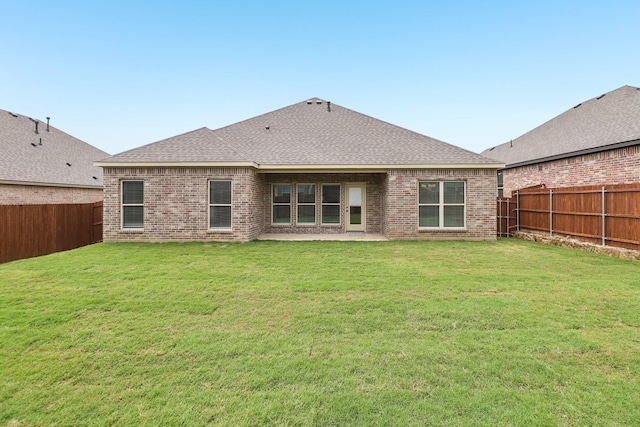 212 Navajo Trl, Alvarado, TX 76009 - rear view of house with a fenced backyard, a yard, roof with shingles, and brick siding