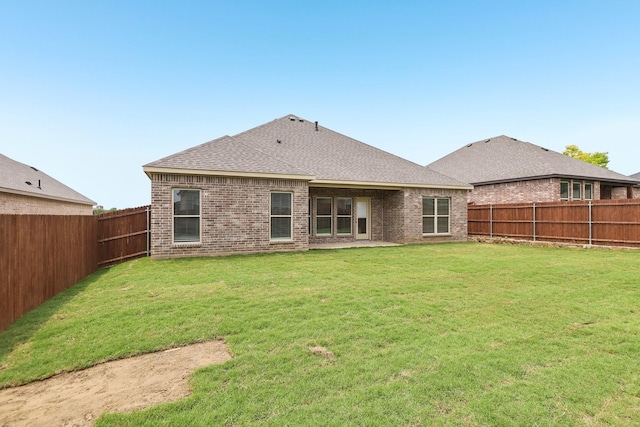 212 Navajo Trl, Alvarado, TX 76009 - rear view of house with brick siding, a fenced backyard, and a shingled roof