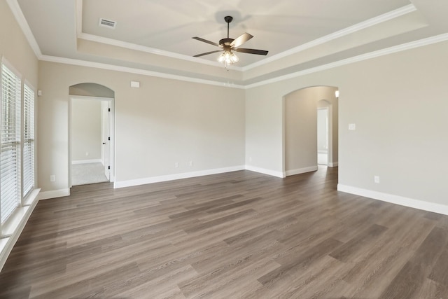 212 Navajo Trl, Alvarado, TX 76009 - spare room with visible vents, wood finished floors, ceiling fan, a raised ceiling, and arched walkways