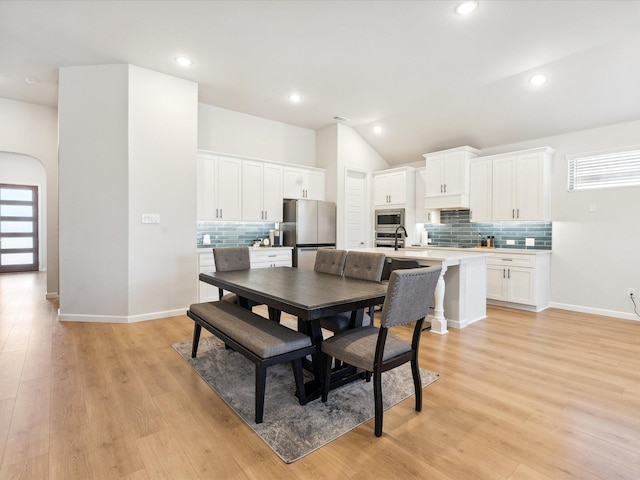 2019 Atlantic Ave, Anna, TX 75409 - kitchen featuring white cabinets, appliances with stainless steel finishes, wood finished floors, tasteful backsplash, and custom exhaust hood