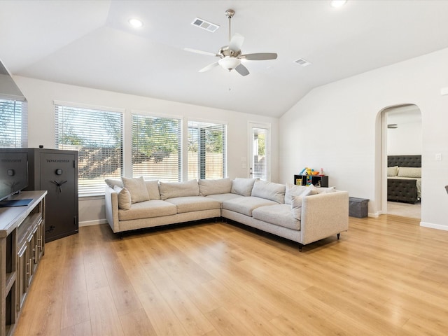 living room featuring light hardwood / wood-style flooring, a wealth of natural light, ceiling fan, and vaulted ceiling