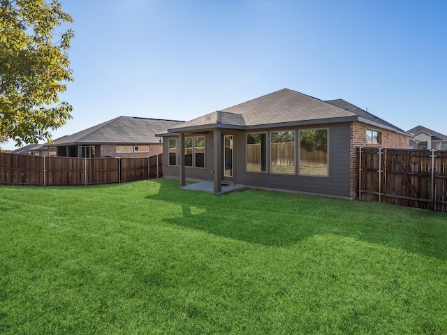 rear view of house featuring a yard