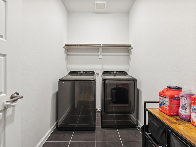 washroom with cabinets, washing machine and dryer, and dark tile patterned flooring