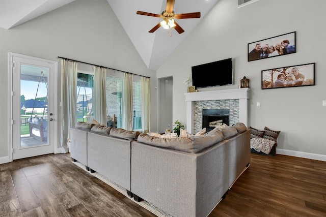 living room featuring dark wood-type flooring, ceiling fan, high vaulted ceiling, and a tile fireplace