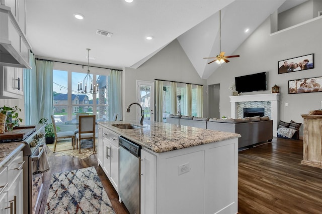 kitchen featuring decorative light fixtures, an island with sink, sink, white cabinets, and stainless steel appliances