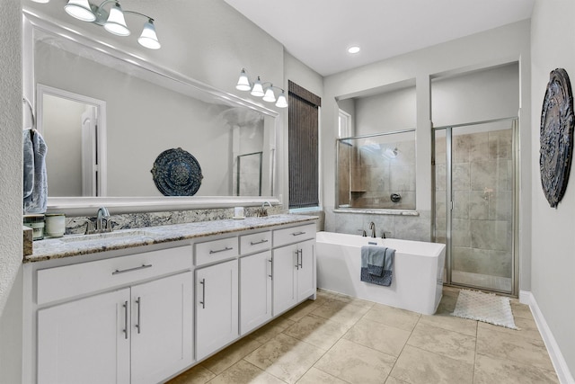 bathroom with vanity and shower with separate bathtub