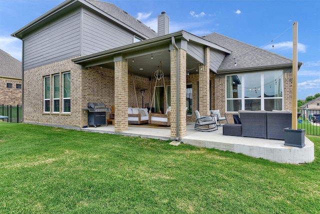 rear view of property with a lawn, an outdoor living space with a fire pit, and a patio