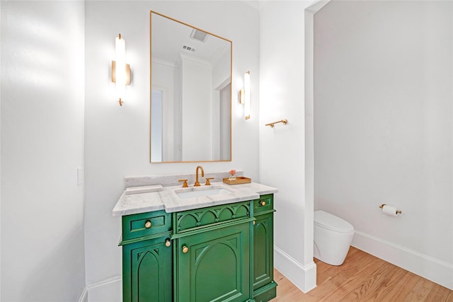 bathroom featuring wood-type flooring, vanity, and toilet