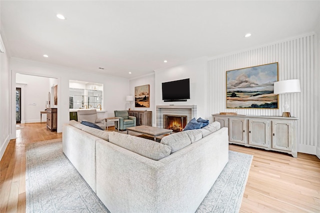 living room with light hardwood / wood-style flooring and ornamental molding