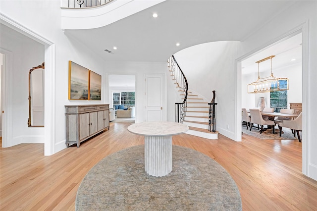 foyer with light hardwood / wood-style floors and an inviting chandelier