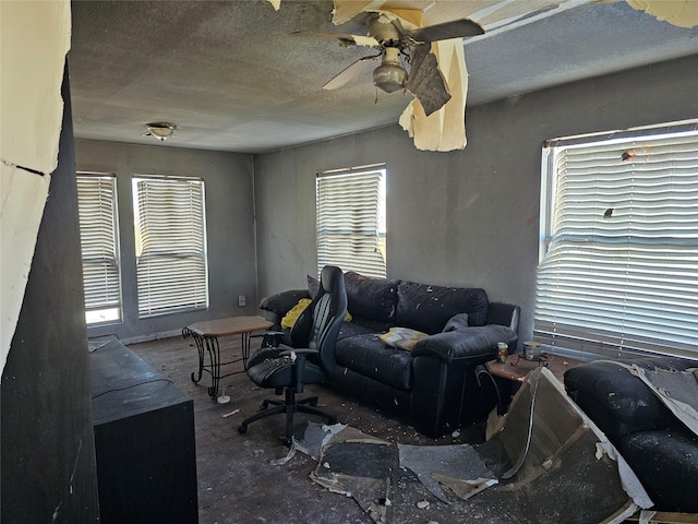 living room with ceiling fan and a textured ceiling