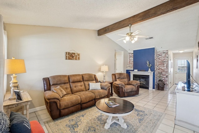 living area featuring lofted ceiling with beams, light tile patterned floors, a textured ceiling, and a glass covered fireplace