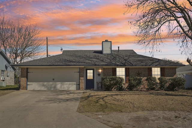 view of front of property with a garage, brick siding, driveway, roof with shingles, and a chimney