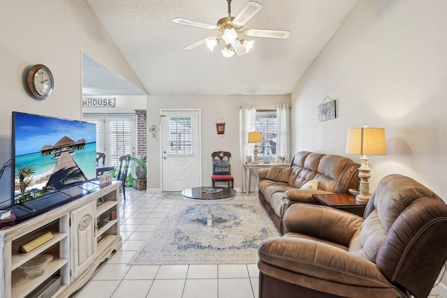 living area with light tile patterned floors, ceiling fan, vaulted ceiling, and a textured ceiling