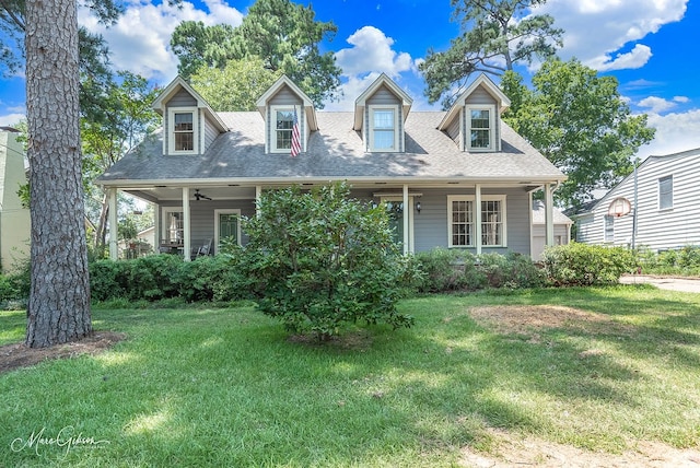 cape cod home featuring ceiling fan and a front yard