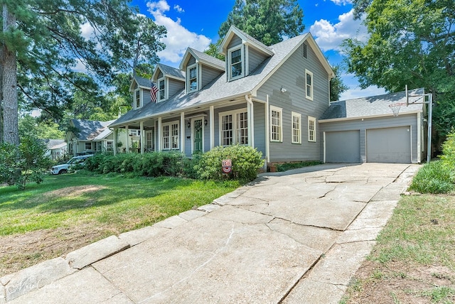 new england style home featuring a garage, a front yard, and covered porch