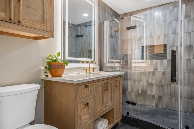 bathroom featuring vanity, walk in shower, and toilet