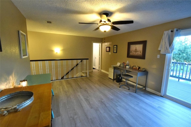 office space with ceiling fan, wood-type flooring, and a textured ceiling