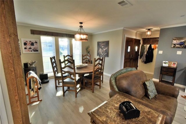 dining area featuring light hardwood / wood-style flooring and ornamental molding