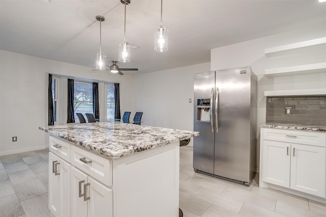 kitchen featuring pendant lighting, tasteful backsplash, white cabinets, a kitchen island, and stainless steel fridge with ice dispenser