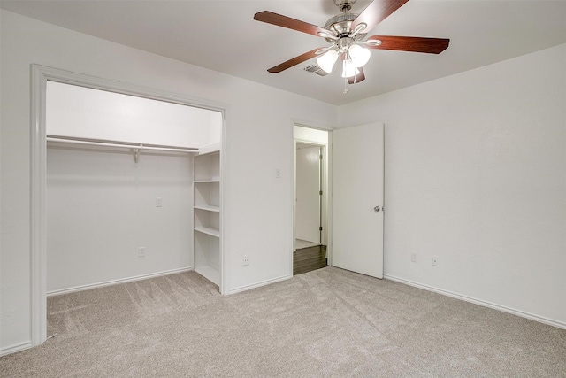 unfurnished bedroom with ceiling fan, a closet, and light carpet