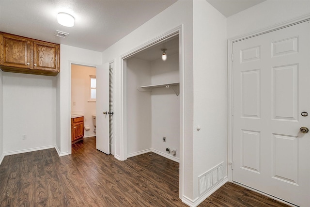 clothes washing area featuring cabinets, electric dryer hookup, and dark hardwood / wood-style flooring