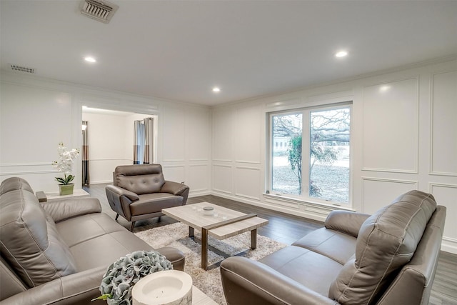 living room with hardwood / wood-style flooring and ornamental molding