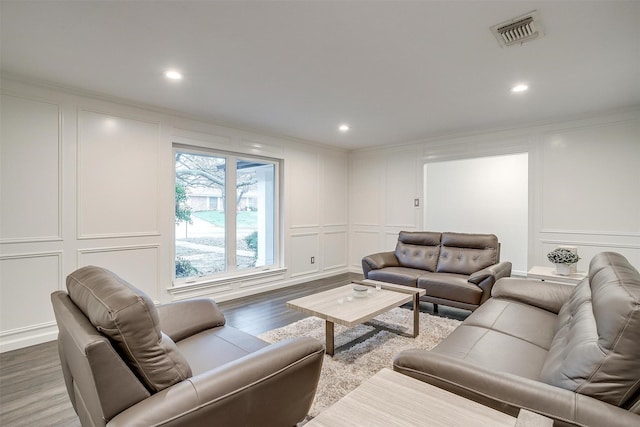 living room with ornamental molding and wood-type flooring