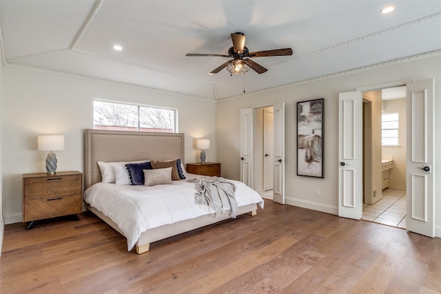 bedroom featuring ensuite bathroom, lofted ceiling, hardwood / wood-style floors, and ceiling fan