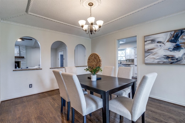 dining room with a notable chandelier, a tray ceiling, ornamental molding, and dark hardwood / wood-style floors