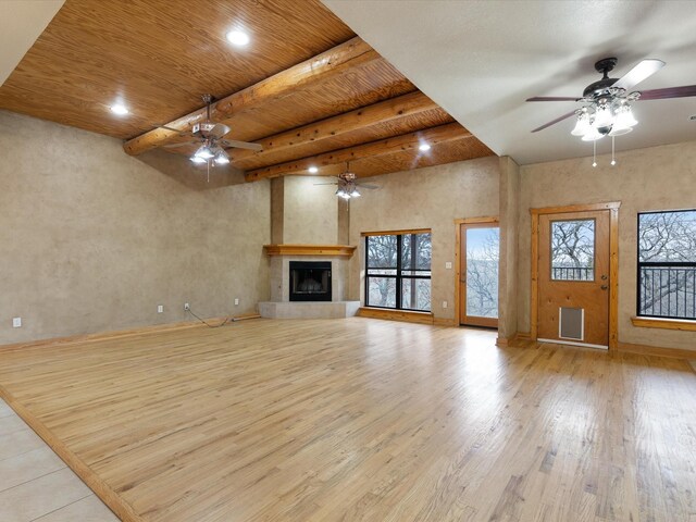 unfurnished living room with wood ceiling, a ceiling fan, wood finished floors, a glass covered fireplace, and beamed ceiling