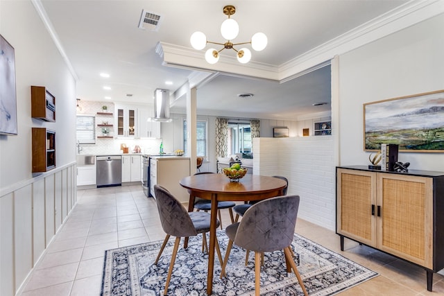 dining area with an inviting chandelier, light tile patterned floors, and ornamental molding