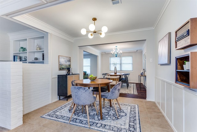 dining area with light tile patterned flooring, a notable chandelier, and crown molding