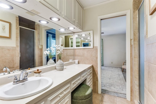 bathroom with tile walls, crown molding, a shower with door, and tile patterned floors