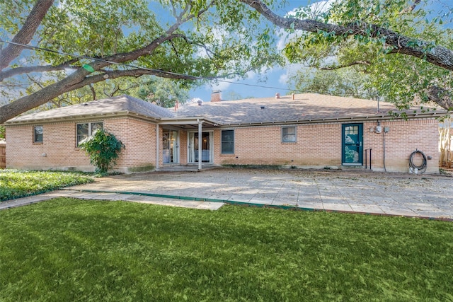 back of property with a patio area and a lawn