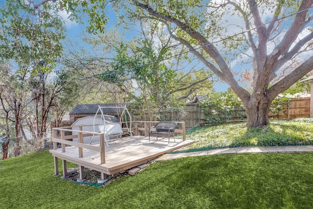 view of yard featuring a wooden deck and a storage shed