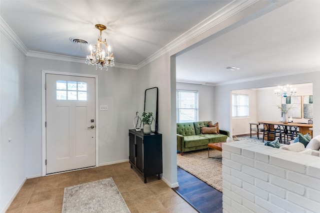 tiled foyer entrance featuring ornamental molding and a chandelier