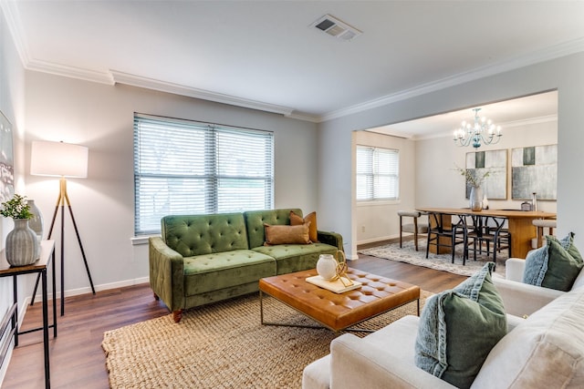 living room with ornamental molding, a baseboard heating unit, hardwood / wood-style floors, and a chandelier