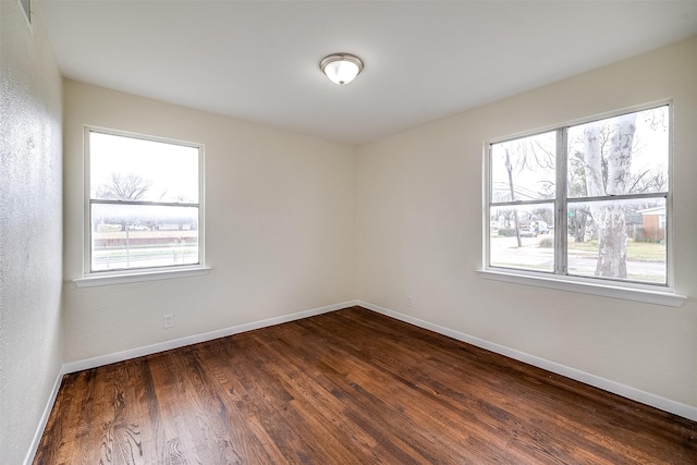 unfurnished room with dark wood-type flooring and a healthy amount of sunlight