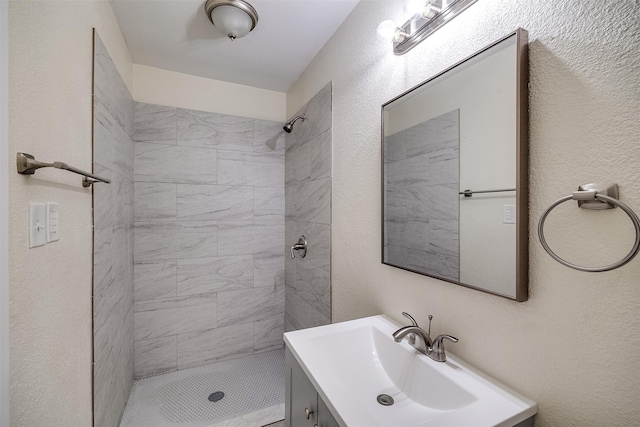 bathroom featuring vanity and tiled shower