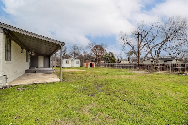 view of yard with a storage unit and a patio area