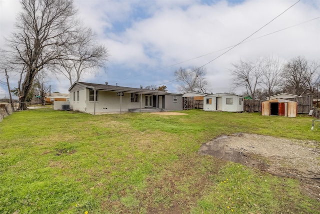 back of house featuring a lawn, a patio area, and a storage unit