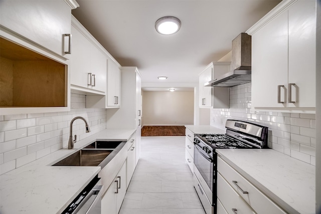 kitchen with sink, white cabinetry, stainless steel range with gas stovetop, light stone countertops, and wall chimney range hood