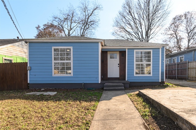 bungalow with a front lawn and fence