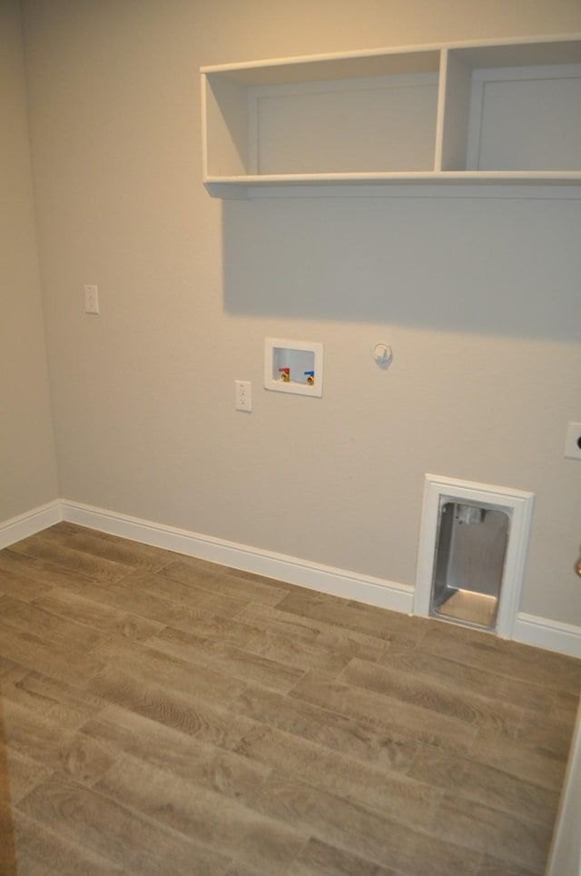 clothes washing area featuring wood-type flooring, hookup for a gas dryer, and hookup for a washing machine